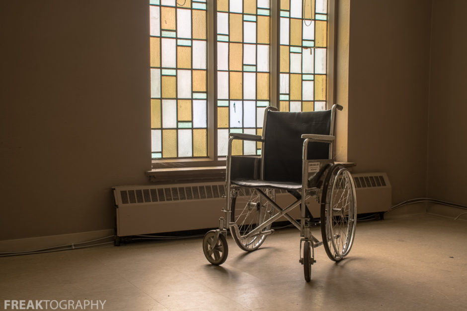 stained glass window and a wheelchair in an abandoned ontario church