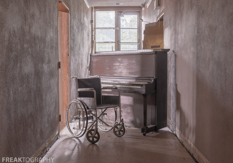 A bracketed HDR photo of a wheelchair and piano taken while urban exploring an abandoned church