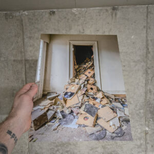 A pile of decayed vinyl records spilling out of a doorway inside the attic of an abandoned funeral home and music school in Detroit.