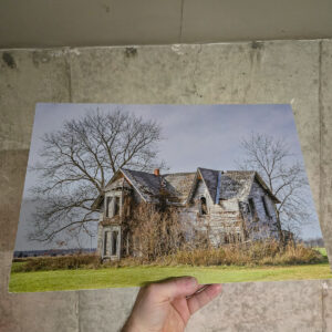 The abandoned Guyitt House, a vine covered Victorian farmhouse with a damaged roof, standing in a rural Ontario field.
